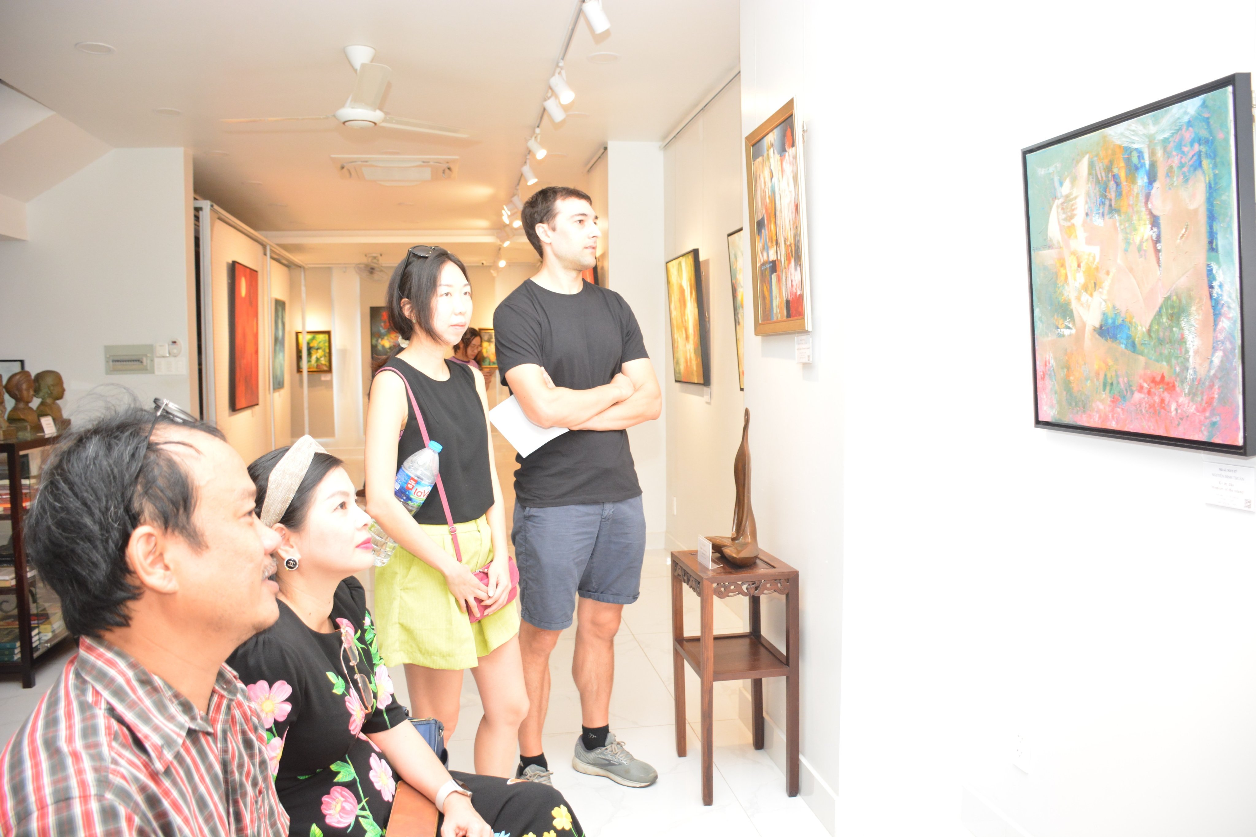 Du khách quốc tế thưởng lãm tranh tại buổi khai mạc triển lãm ở TP. Hồ Chí Minh - Ảnh: Trần Lợi.
